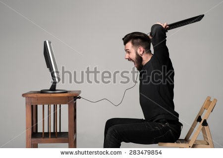 man about to smash his keyboard on a computer monitor