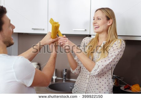 stock photo of a cute couple sword fighting with pasta