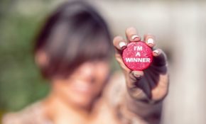 Woman-Holding-Red-button-Saying-Im-A-Winner